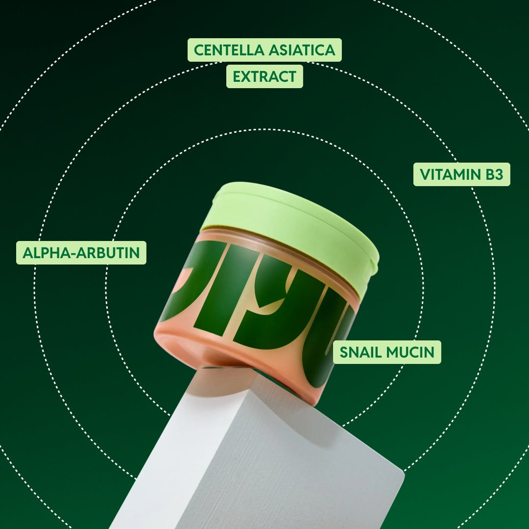 Jar of toner pads tilted on a white block, labelled with alpha-arbutin, centella asiatica, vitamin B3 and snail mucin